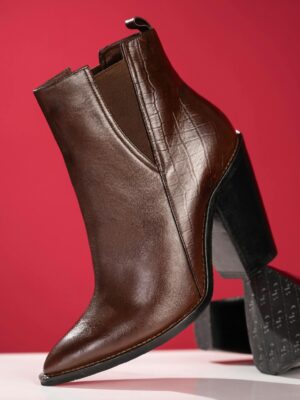 Stylish brown leather ankle boot with chunky heel against a vibrant red backdrop.