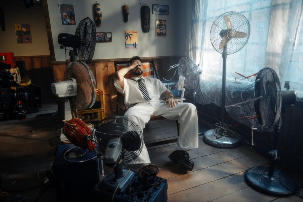 Homme se détendant au milieu de plusieurs ventilateurs dans une pièce au style vintage Theaurabelle- ventilateurs et climatiseurs